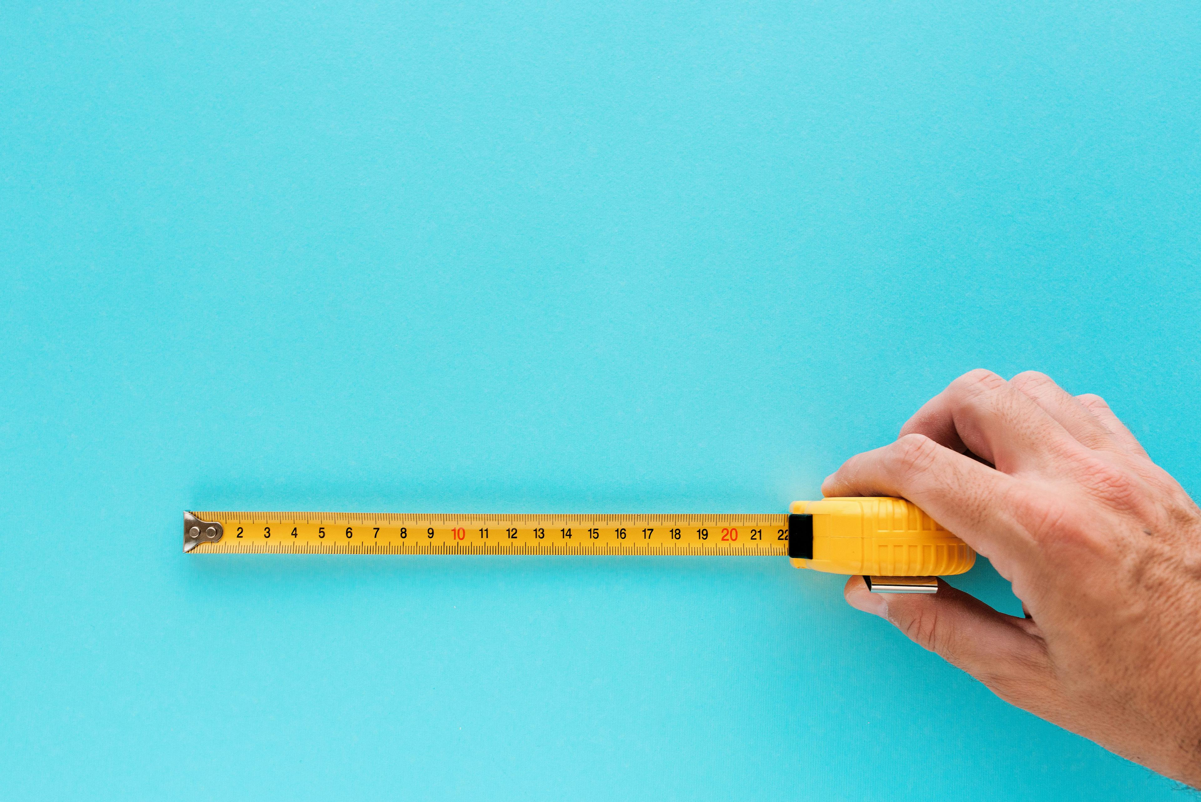 yellow measuring tape on turquoise background | image credit: bits and splits stock.adobe.com