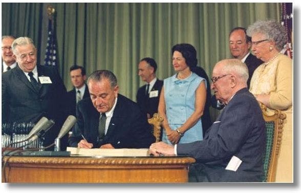 Lyndon Johnson signing Medicare into law with Harry S. Truman looking on | Image credit: LBJ Presidential Library