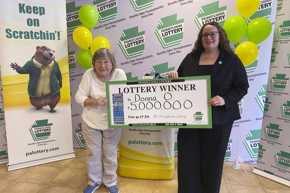 Donna Osborne, 75, left, posing for a photo with PA Lottery Deputy Director of Corporate Sales Staci Coombs at Lottery Headquarters in Middletown, Pa. (Pennsylvania Lottery via AP)