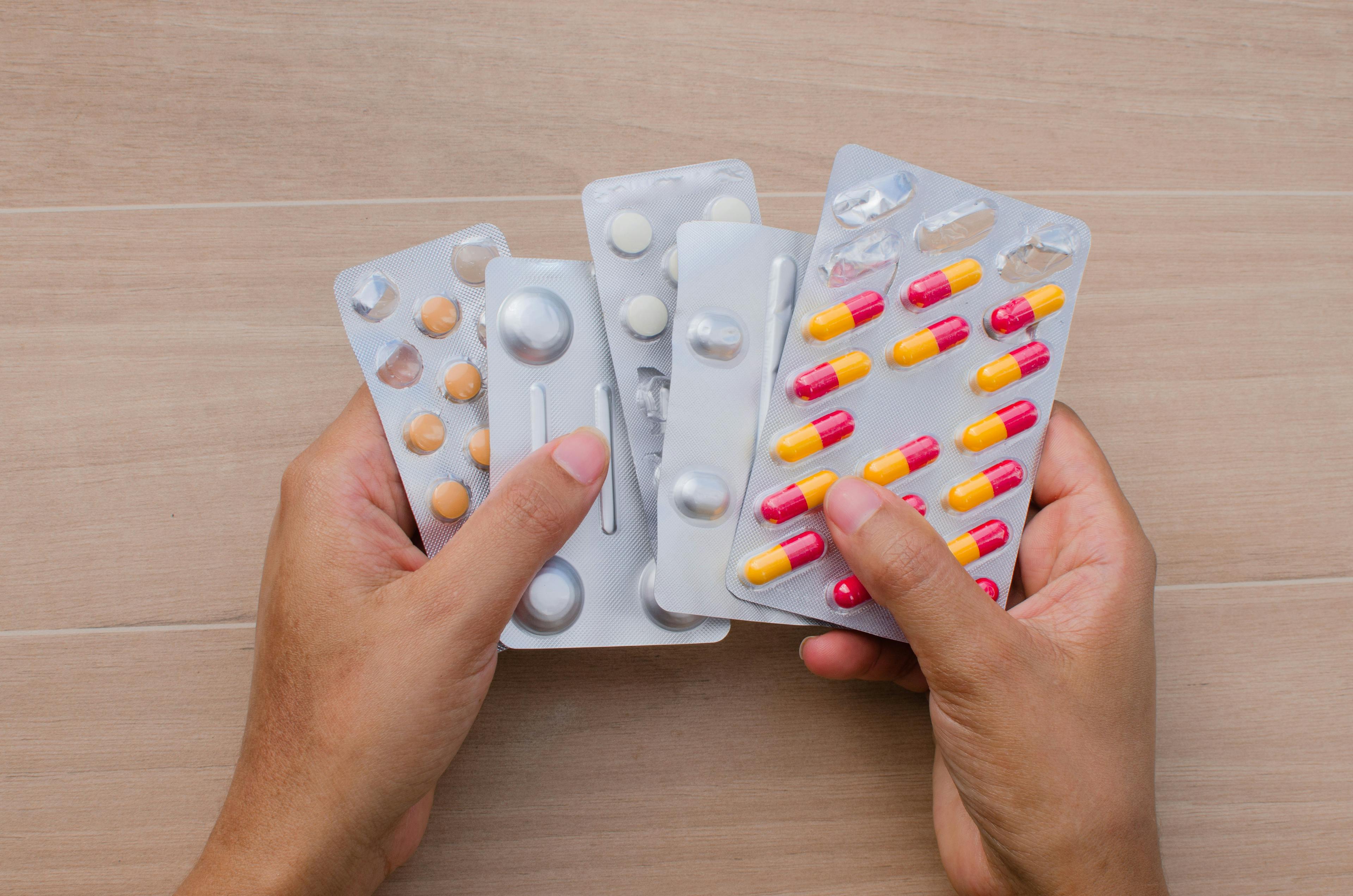 a person holding five blister packs of pills | Image credit: JEROSenneGs stock.adobe.com