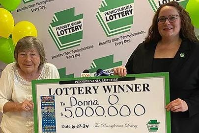 This image provided by the Pennsylvania Lottery shows Donna Osborne, 75, left, posing for a photo with PA Lottery Deputy Director of Corporate Sales Staci Coombs at Lottery Headquarters in Middletown, Pa. (Pennsylvania Lottery via AP).