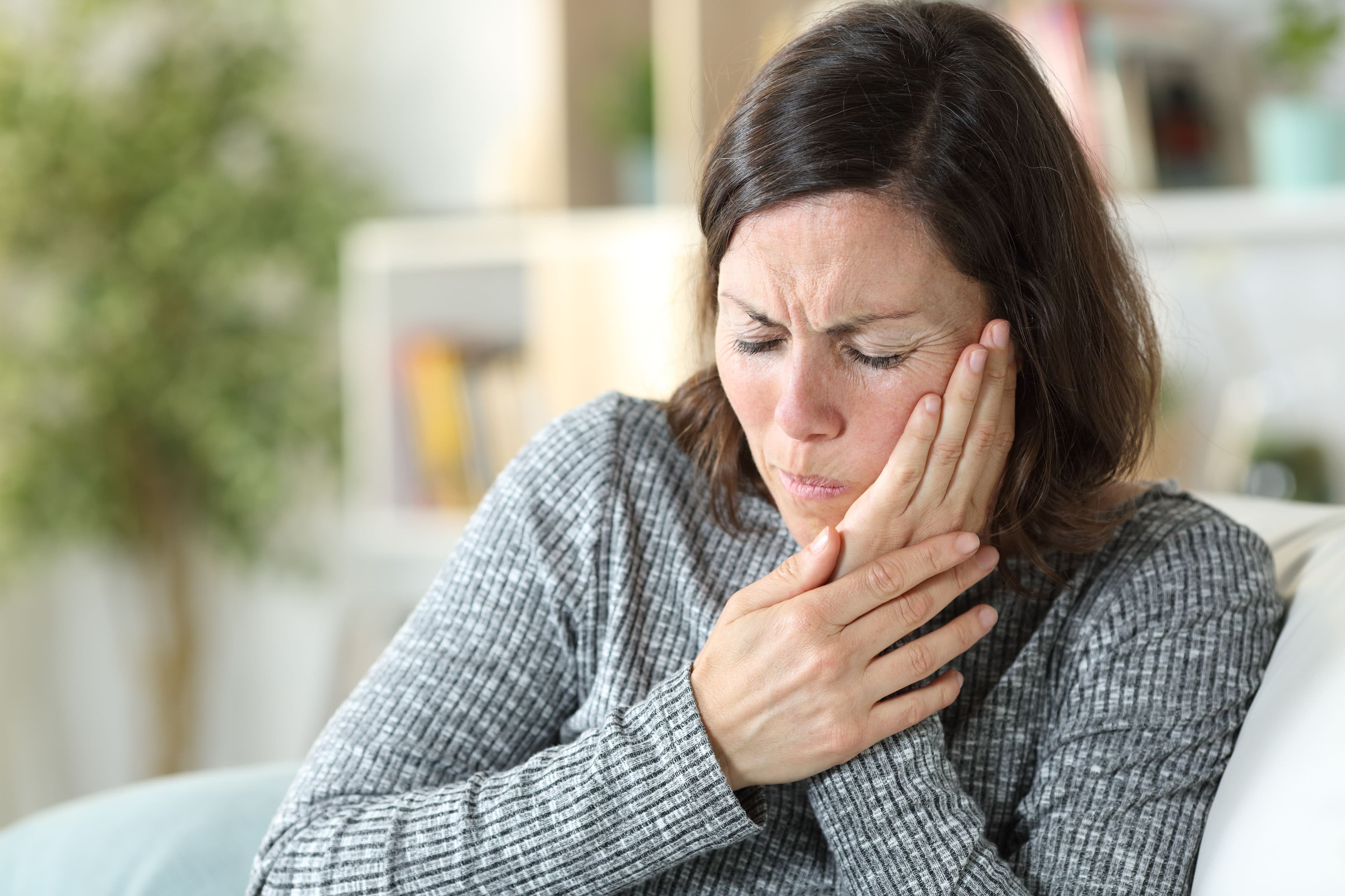 woman holding side of face with a painful grimace | ©pheelingsmedia stock.adobe.com